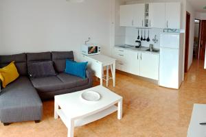 a living room with a couch and a table and a kitchen at EL MORRO SEA VIEW APARTMENT in San Agustin