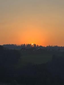 a sunset over a field with trees in the background at Hilltop-house, near train, 180° panorama, friendly in Birmensdorf +19 photos