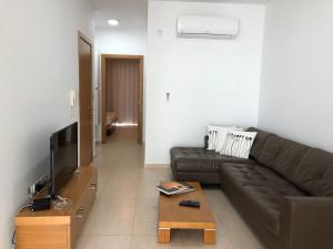 sala de estar con sofá marrón y TV en Best location in Sliema, en Sliema