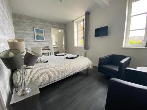 1 dormitorio con 1 cama y 1 silla negra en Relais Les Loges-Etretat, en Les Loges