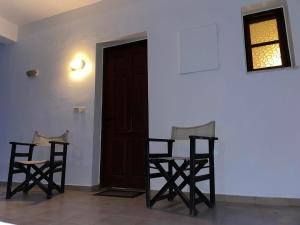 a room with two chairs and a table and a door at Livadia Studios in Ropanianá