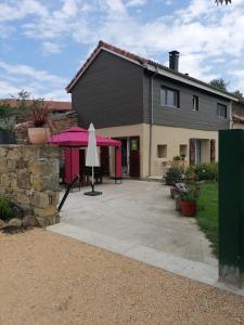 una casa con una sombrilla rosa en la entrada en Maison entre Campagne et Foret, en Aspret-Sarrat