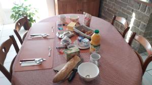 einen rosa Tisch mit Essen und Brot drauf in der Unterkunft Maison de Caractère Maryann56 in Noyal-Muzillac