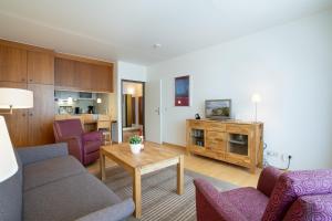 ein Wohnzimmer mit lila Stühlen und einem Tisch in der Unterkunft Haus Meeresstrand Wohnung 207 in Scharbeutz