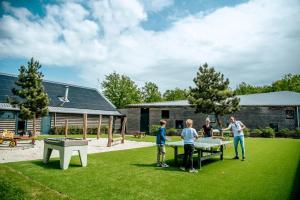 a group of people playing ping pong in a yard at EuroParcs Ruinen in Ruinen +41 photos