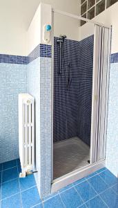 y baño con ducha y azulejos azules. en Fuori Porta Apartment, en Camerano