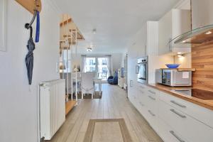 een keuken met witte kasten en een eetkamer bij Seebrücke Seebrücke Appartement 22 in Scharbeutz