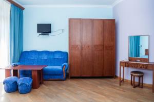 a living room with a blue couch and a table at Syuniq Hotel in Goris