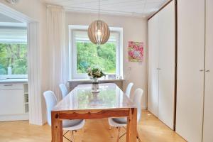 ein Esszimmer mit einem Holztisch und weißen Stühlen in der Unterkunft Gorch Fock Ring Strand und Meer Appartement 1 in Scharbeutz