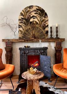 ein Wohnzimmer mit einem Kamin und orangefarbenen Stühlen in der Unterkunft Ferienwohnungen „Zur Alten Schule“ direkt an der Elbe in Lutherstadt Wittenberg