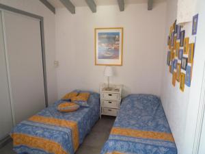 ポルト・ヴェッキオにあるRésidence les Hameaux de Bocca del Oroのベッドルーム1室(ベッド2台、ナイトスタンド付)