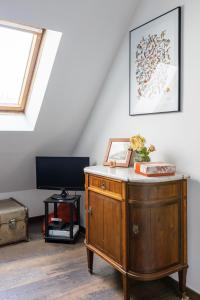 a room with a wooden dresser in a attic at Veeve - Footsteps from the Arc de Triomphe in Paris