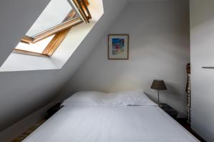 um quarto com uma cama e uma janela em Veeve - Footsteps from the Arc de Triomphe em Paris
