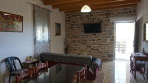 sala de estar con pared de ladrillo y TV en Oasis house - for relaxing holidays near the beach en Kalamaki