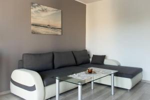 uma sala de estar com um sofá e uma mesa em Apartment 50m2 with a large living room, bedroom, balcony and free private parking em Gdansk