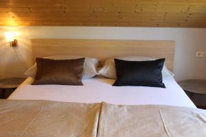 a large bed with two pillows on top of it at Studio Maria in Egg