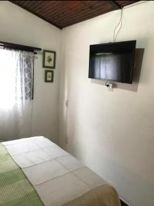 a bedroom with a bed and a flat screen tv at Casa charmosa in Penedo