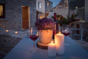 een tafel met twee glazen wijn en twee kaarsen bij Kapetan Matapas 16th Cen. Tower in Areopolis