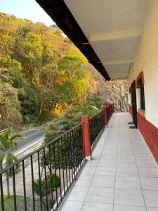 einen Balkon eines Gebäudes mit einem Zaun und einer Straße in der Unterkunft Traditional Sierra Leon Oceanfront Rooms - Adults Only in Puerto Vallarta