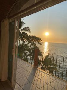 a balcony with a view of the ocean at sunset at Traditional Sierra Leon Oceanfront Rooms - Adults Only in Puerto Vallarta