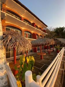 un edificio con una fila di ombrelloni in un cortile di Traditional Sierra Leon Oceanfront Rooms - Adults Only a Puerto Vallarta