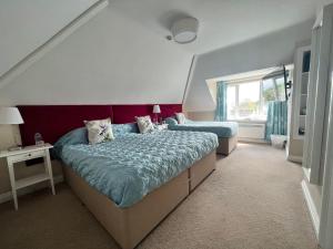 1 dormitorio con 2 camas y ventana en Swan Hotel, en Wotton-under-Edge