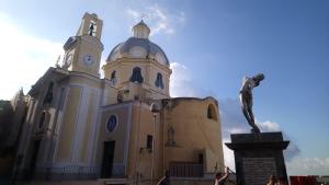 a large building with a statue in front of it at Happy House Corricella in Procida +4 photos