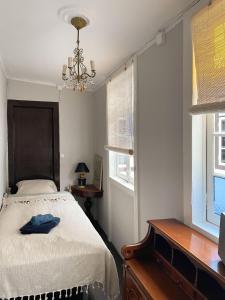 1 dormitorio con cama y lámpara de araña en Gato Azul - Coliving, en La Orotava