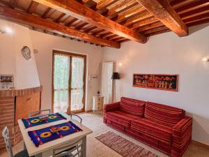 ein Wohnzimmer mit einem roten Sofa und einem Tisch in der Unterkunft Villetta Oreste in Saturnia