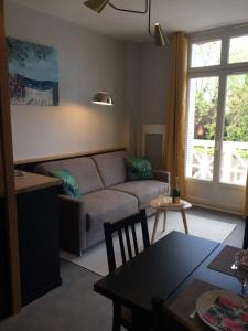 ein Wohnzimmer mit einem Sofa und einem Tisch in der Unterkunft Dinard: studio à 100 m de la plage de L'Ecluse in Dinard