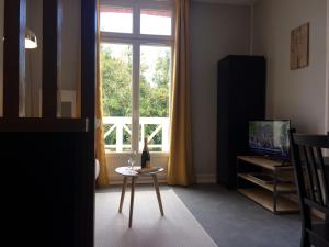 a living room with a table and a window at Dinard: studio à 100 m de la plage de L'Ecluse in Dinard