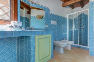 a blue tiled bathroom with a toilet and a sink at VILLA MARIA - CAPO D'ORSO - HOME and MORE in Palau +37 photos