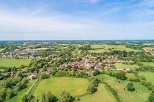 an aerial view of a small village in a green field at Adorable cottage with a log burner in heavenly village - Constable Lodge in Nayland