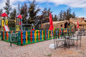 a playground with a colorful play area with a table and chairs at Salma Palms Hôtel in Madkhal Meski