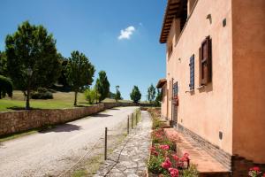 a road next to a building with flowers on the side at Residence Maria Giulia in Corciano