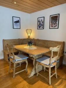 una mesa de madera con 2 sillas y una lámpara. en Am Romberg, en Dornbirn