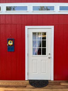 a red building with a white door and a window at McMillan Ranch Yosemite in Coarsegold