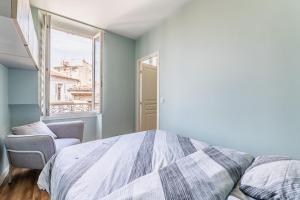 Schlafzimmer mit einem Bett und einem Fenster in der Unterkunft Appartements Marseille cours Julien in Marseille