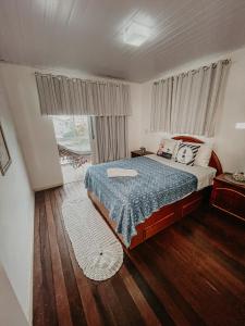 1 dormitorio con cama y ventana en Pousada Canto do Pescador, en Bombinhas