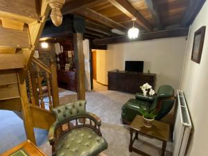 a living room with a couch and chairs and a television at Great House Farm Luxury Pods and Self Catering in Crickadarn