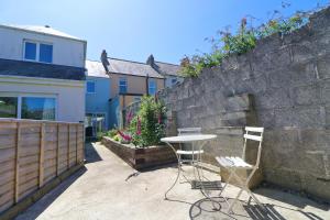 a table and two chairs in front of a wall at Townhouse, close to harbour with sea views in Padstow