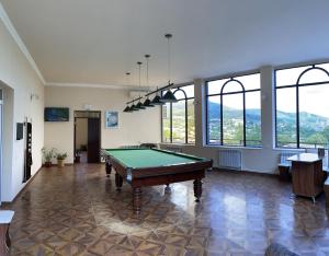 a pool table in a room with windows at Yolyans Hotel in Goris