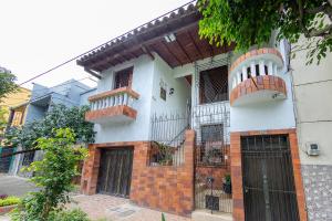 Edificio de ladrillo blanco y rojo con 2 balcones en Ayenda Sarayu House, en Medellín