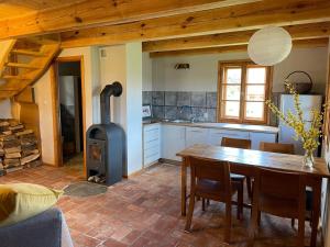 a kitchen with a table and a wood stove at Domy w Lipowie - dom różowy in Lipowo