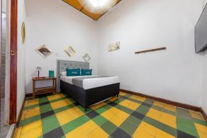 a bedroom with a bed and a checkered floor at Ayenda Sarayu House in Medellín