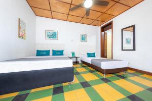 a bedroom with two beds and a checkered floor at Ayenda Sarayu House in Medellín