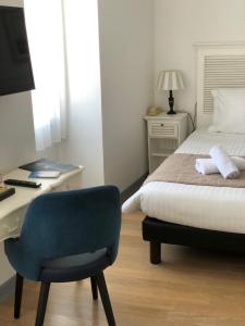 1 dormitorio con cama, escritorio y silla en L'estacade, en Le Croisic