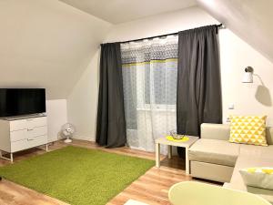 a living room with a couch and a tv at Metsa Apartments in Pärnu