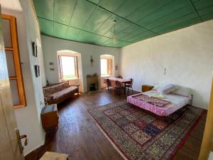 Habitación con cama, sofá y mesa. en Shotgun Hostel en Vuno