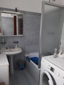 a bathroom with a sink and a washing machine at La casa di Alice e Matteo in Casarza Ligure